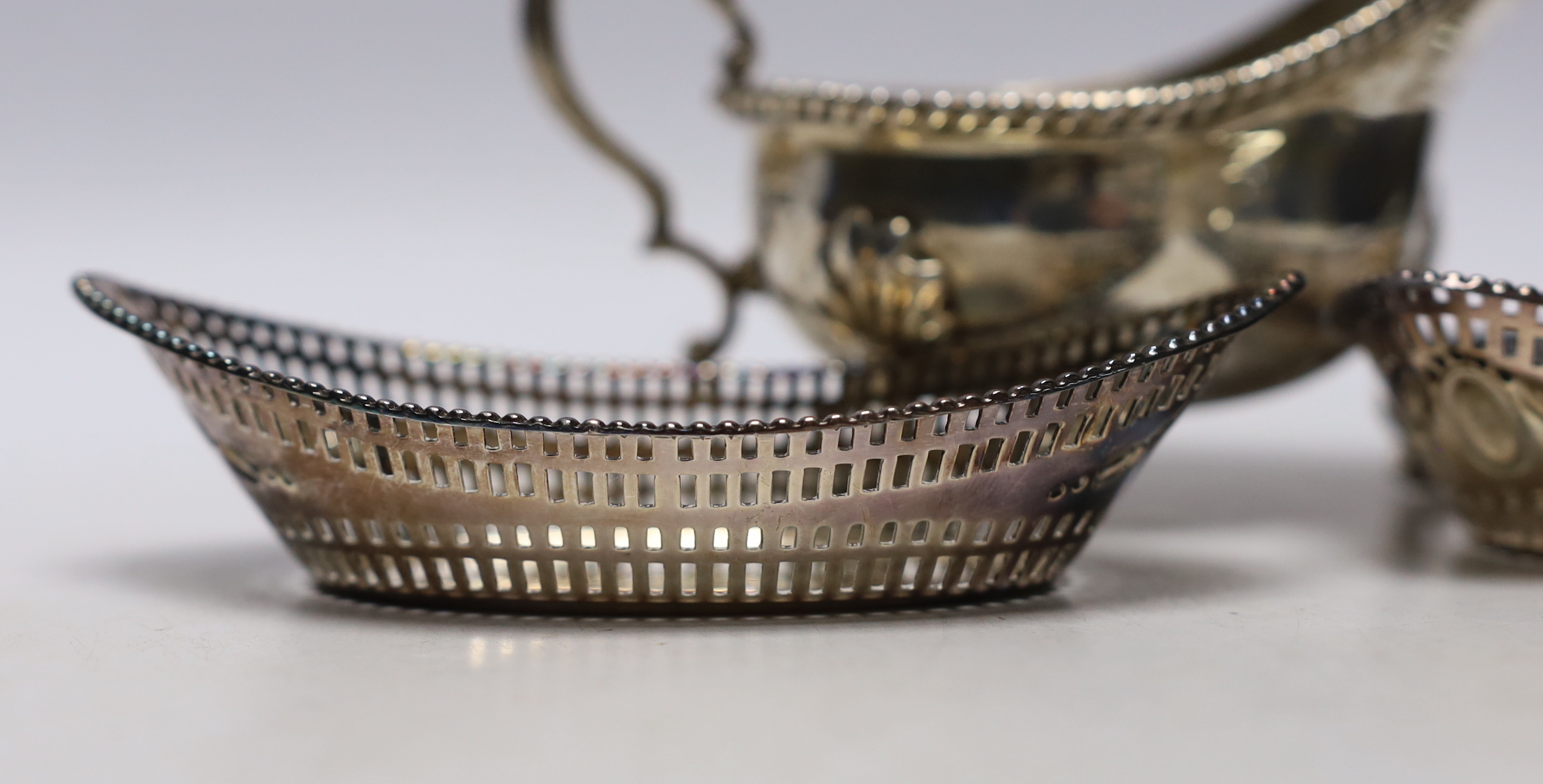 A George V silver sauceboat, Thomas Bradbury & Sons, Sheffield, 1919 and a pair of earlier pierced silver oval bonbon dishes, 13.8cm, 11.3oz.